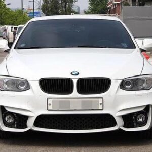 A sleek M4 Conversion Front Bumper with fog lamps for BMW E92 and E93 models, primed and ready for paint.